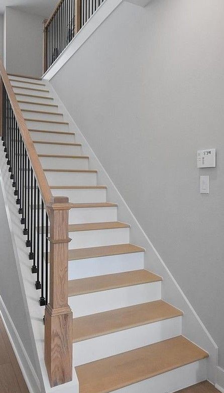 white upwards stair case with light wood stair treads